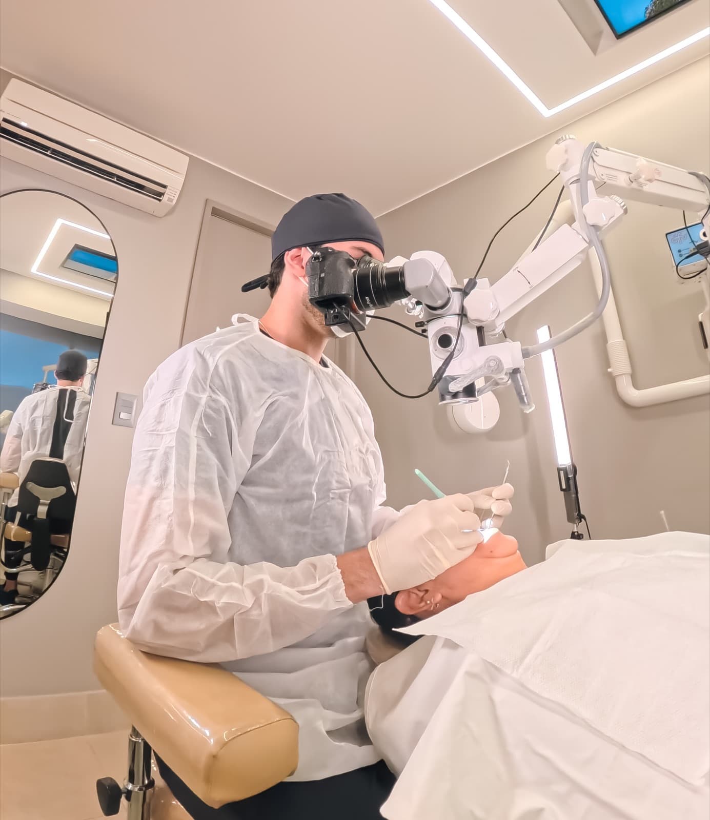 Endodontista utilizando microscópio durante procedimento com anestesia moderna